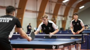 a-photo-of-a-tennis-table-with-two-players-in-acti-tzas1lo0qry7u4iioinwvw-gqzyoliwtiyrbgltuh8xfq